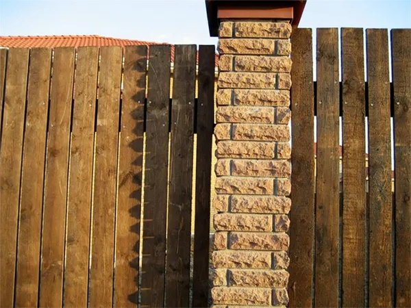 Забор из досок с кирпичными столбами