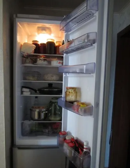 Открытый холодильник CMV 533103 S от «Беко» с примером загрузки продуктами в нише обычной квартиры